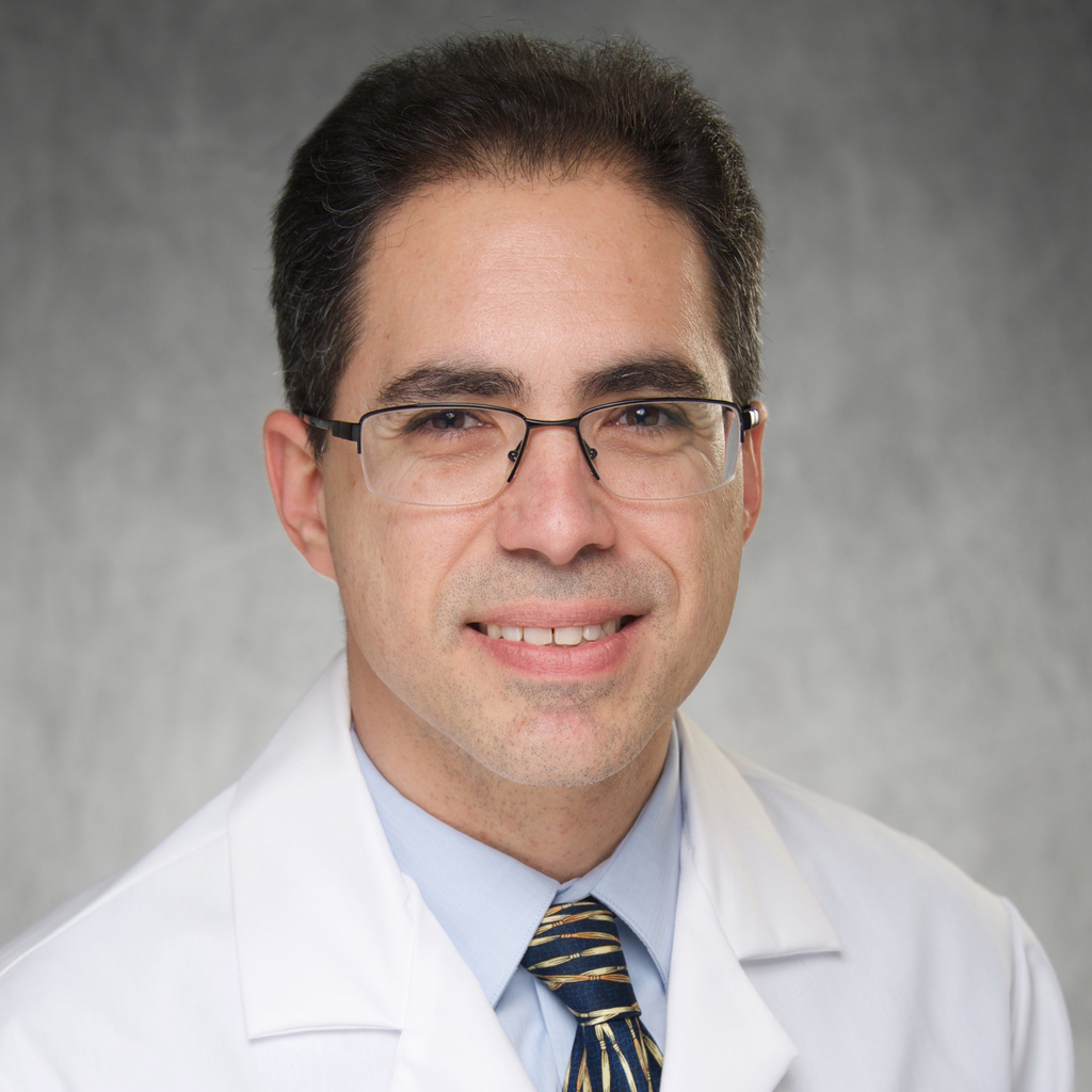 man in white lab coat with blue shirt and necktie